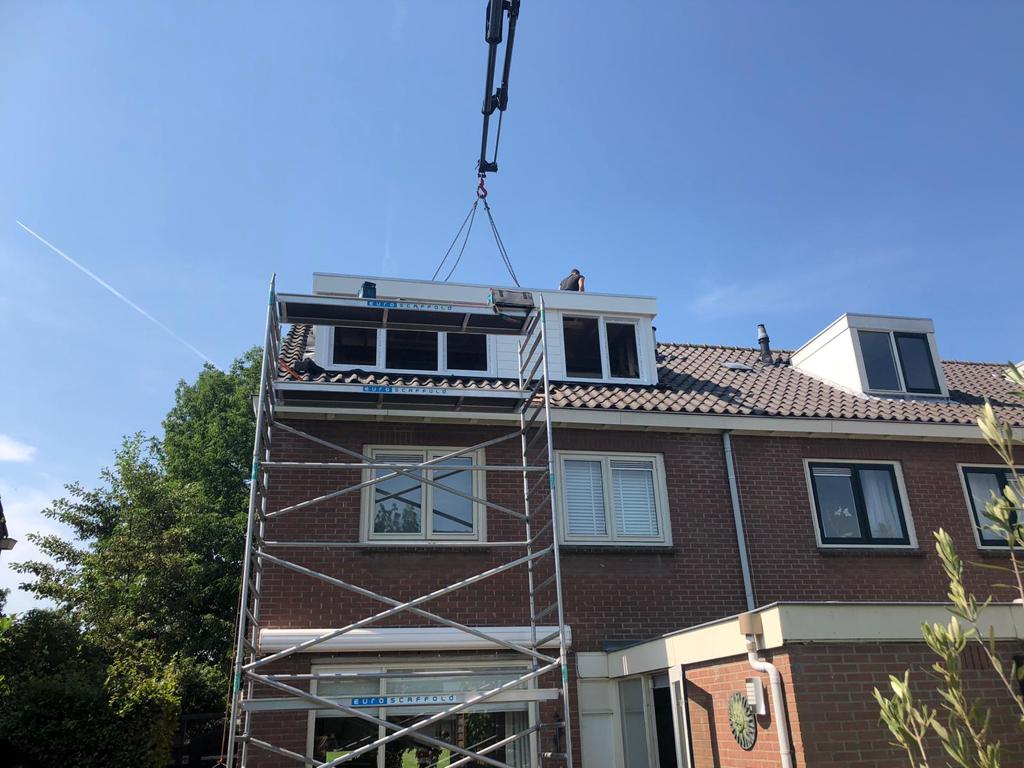 Dakkapel wordt op de woning gehezen